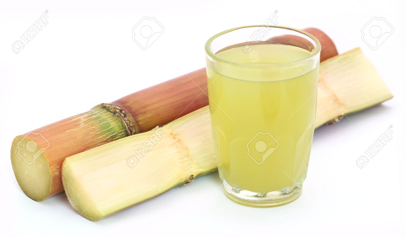 Pieces of sugarcane juice in a glass over white background