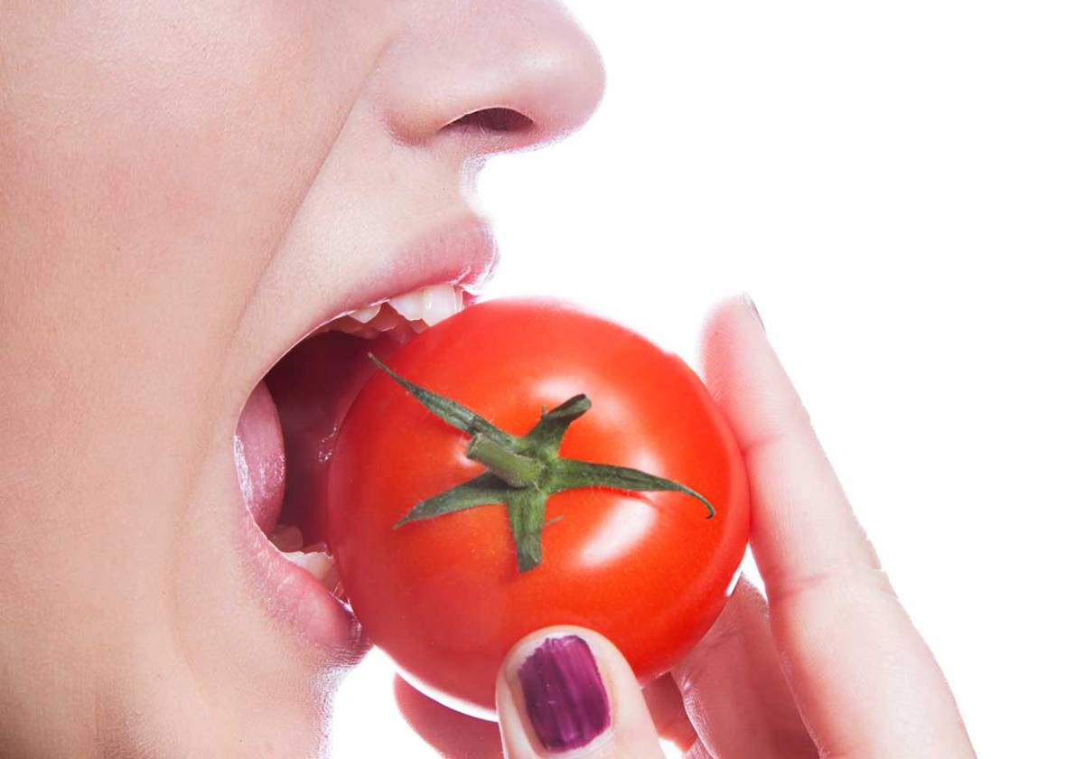 mulher-comendo-tomate